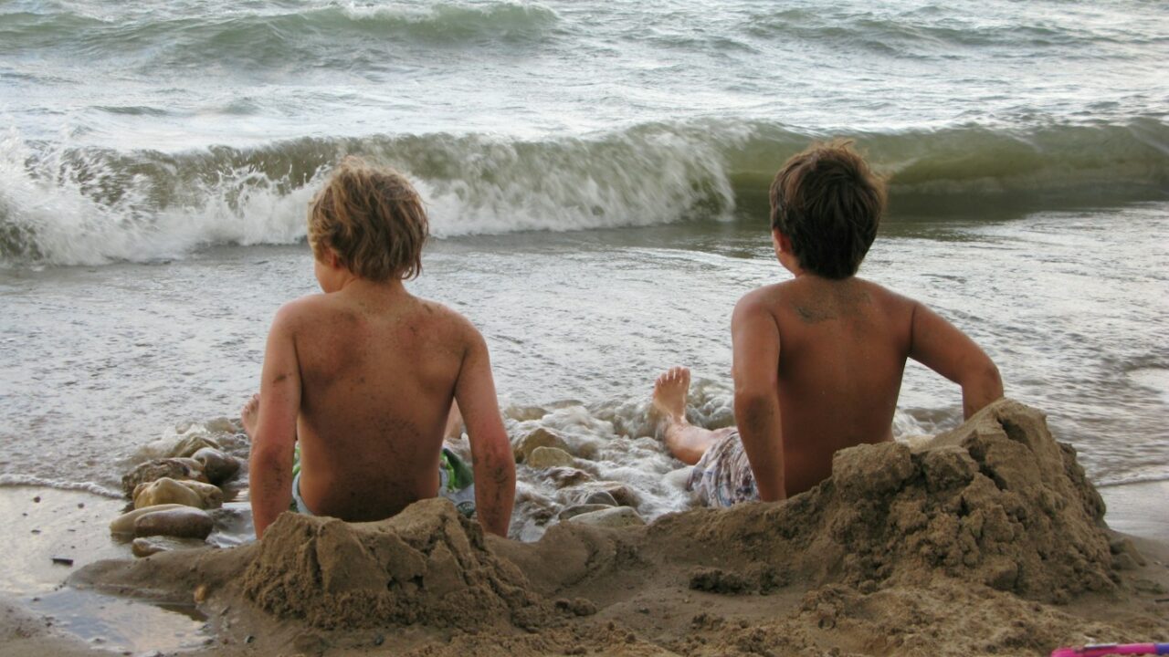 Enfants jouant sur la plage pendant des vacances en famille, photo Deborah L Carlson Unsplash